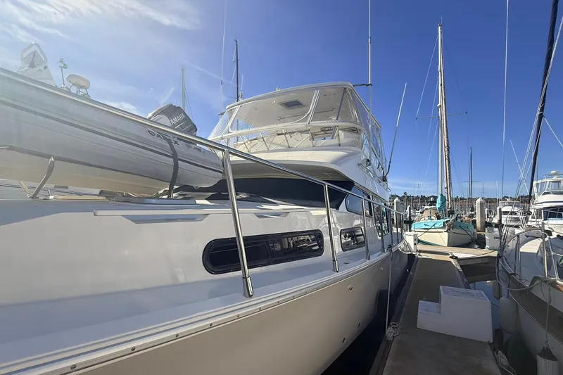Slide: The Image of 2003 Mikelson 50 yacht docked at marina under clear blue sky. - 4