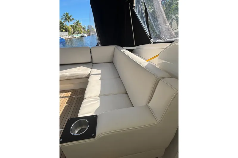 Slide: The Image of Luxurious seating on 2015 Monterey 360 Sport Coupe yacht, featuring beige upholstery and cup holder. - 12