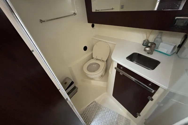 Slide: The Image of 2015 Monterey 360 Sport Coupe bathroom with toilet, sink, and dark wood cabinetry. - 26