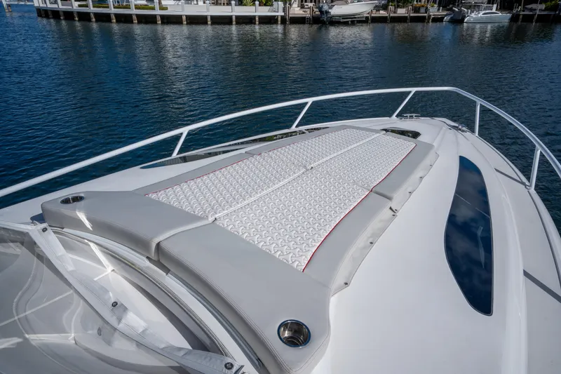 Slide: The Image of 2022 Intrepid 409 Valor boat with cushioned deck, docked by the water. - 10