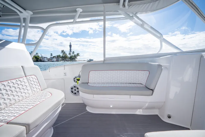Slide: The Image of 2022 Intrepid 409 Valor boat interior with cushioned seating and ocean view. - 14