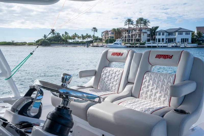Slide: The Image of 2022 Intrepid 409 Valor boat interior with luxury seating and scenic waterfront view. - 18