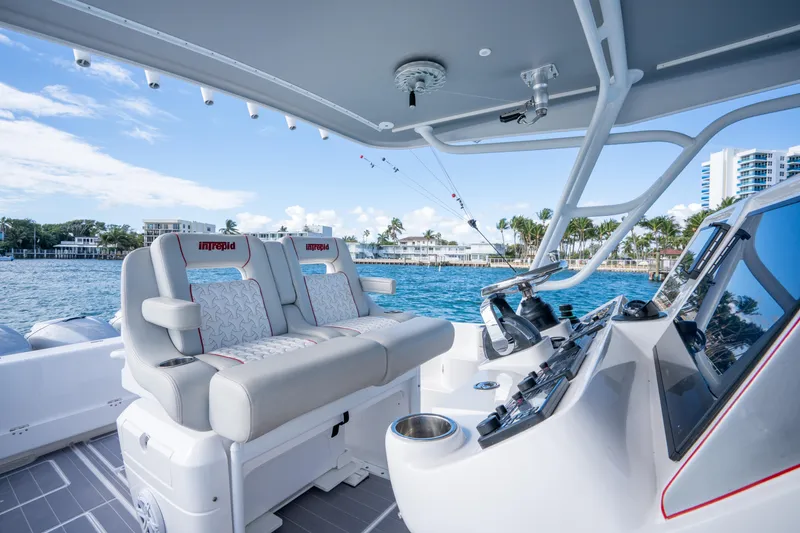 Slide: The Image of 2022 Intrepid 409 Valor boat interior with luxurious seating and modern controls. - 19