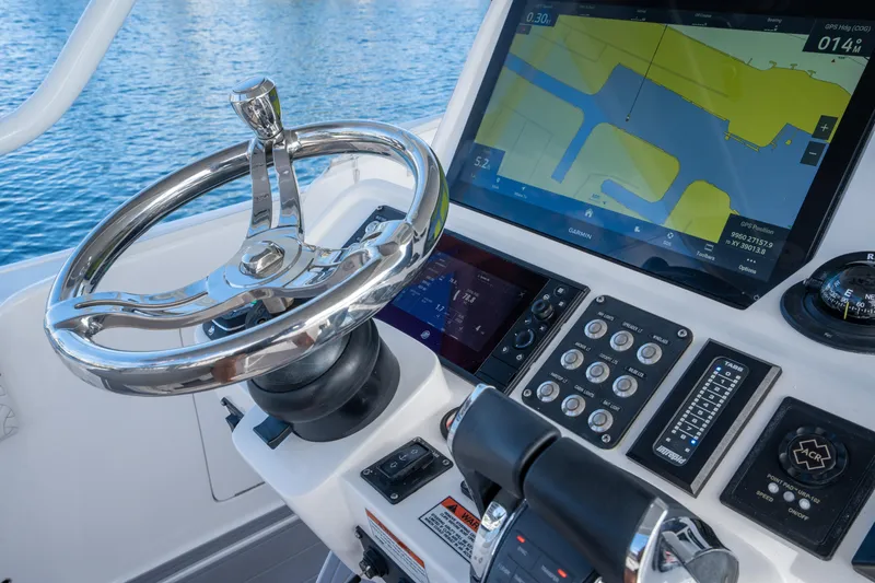 Slide: The Image of 2022 Intrepid 409 Valor helm with GPS display and controls, on calm blue water. - 24