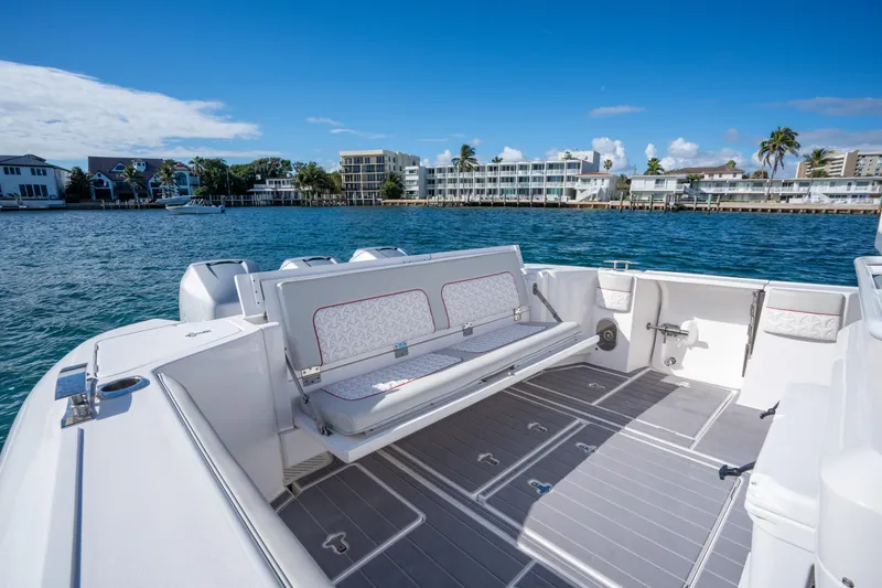 Slide: The Image of 2022 Intrepid 409 Valor boat interior with seating, docked by waterfront buildings. - 27