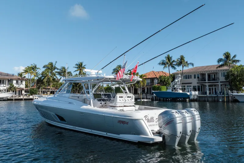Slide: The Image of 2022 Intrepid 409 Valor yacht with triple Mercury engines docked in a scenic waterfront setting. - 3