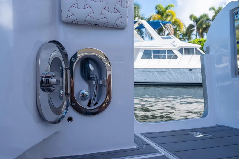 Slide: The Image of 2022 Intrepid 409 Valor boat with chrome fixtures, docked near a larger yacht. - 34