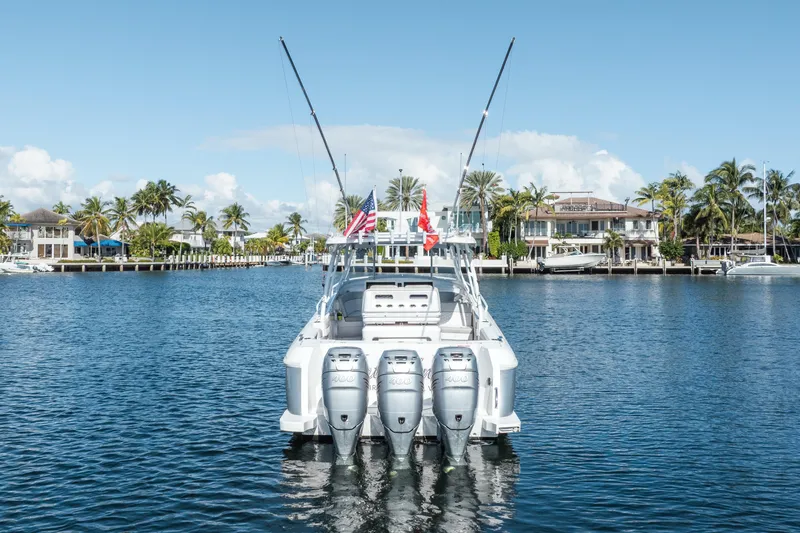 Slide: The Image of 2022 Intrepid 409 Valor boat with triple engines on a sunny waterfront. - 4