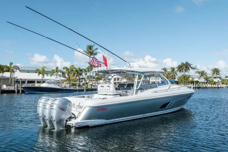 Slide: The Image of 2022 Intrepid 409 Valor boat on water, featuring triple outboard engines and fishing rods. - 5