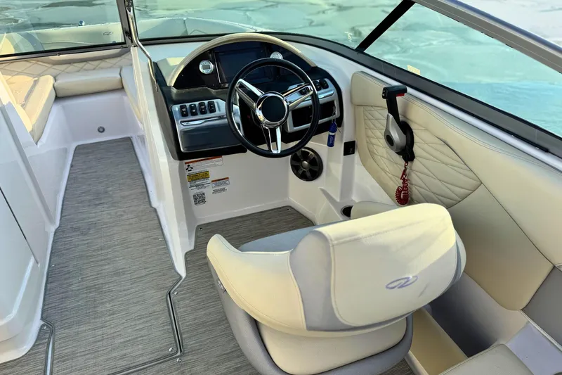 Slide: The Image of 2019 Regal 23 OBX boat interior with steering wheel and beige seating. - 10