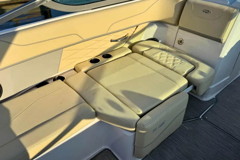 Slide: The Image of 2019 Regal 23 OBX boat interior with beige seating and cup holders. - 12