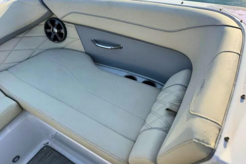 Slide: The Image of 2019 Regal 23 OBX boat interior with beige seating and speaker. - 23