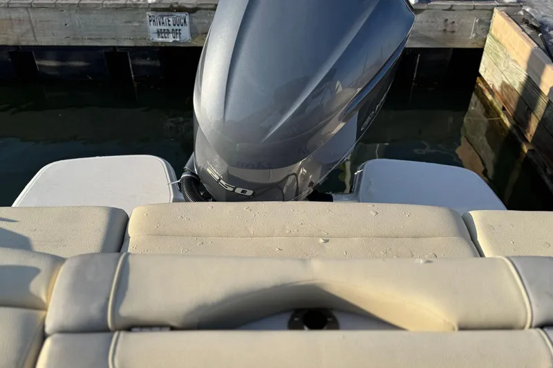 Slide: The Image of 2019 Regal 23 OBX boat with outboard motor at dock, beige seating visible. - 27