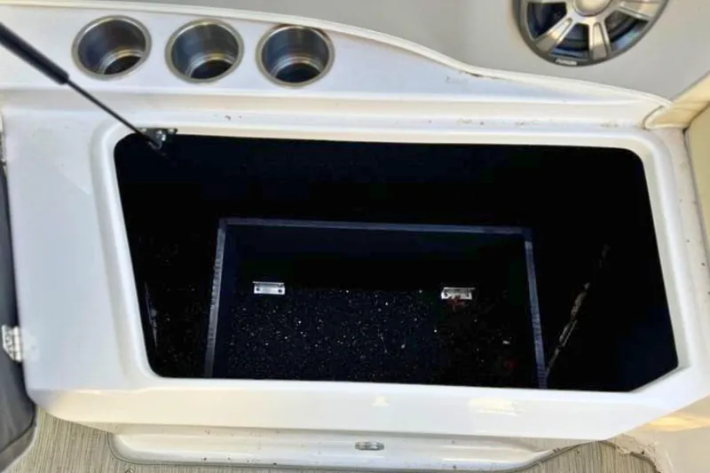 Slide: The Image of Open storage compartment on 2019 Regal 23 OBX boat with cup holders and speaker. - 8