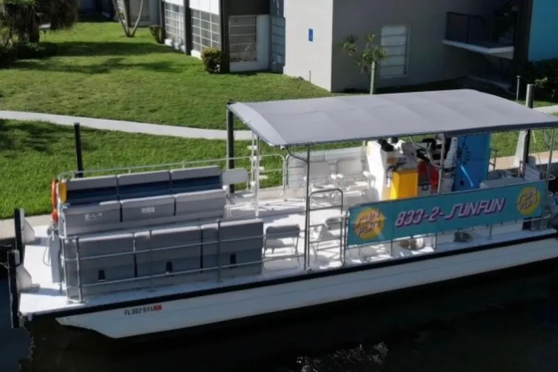 The Image of 2020 A&M Manufacturing 32 Pontoon boat docked near a grassy area. - 0