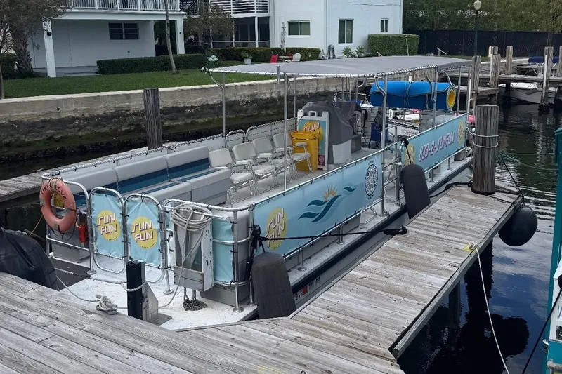 Slide: The Image of 2020 A&M Manufacturing 32 Pontoon docked, featuring seating and safety equipment. - 3