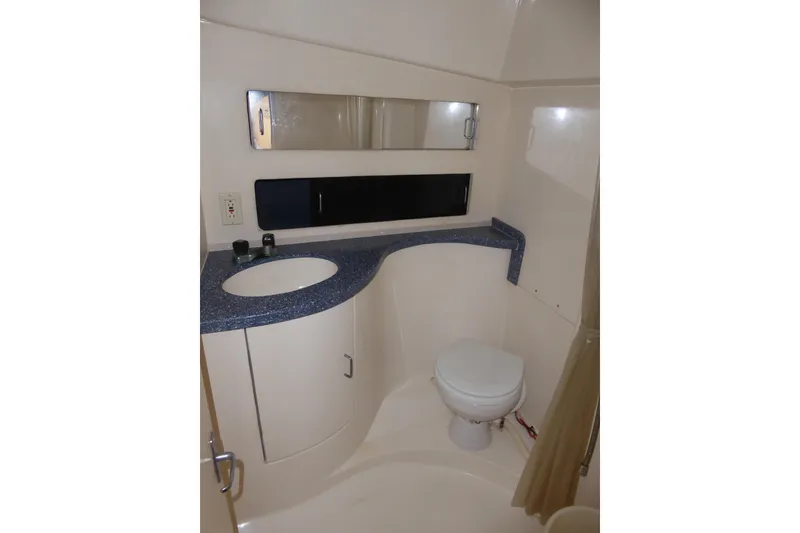 Slide: The Image of 1996 Luhrs 320 Tournament boat bathroom with sink, toilet, and mirror. - 13