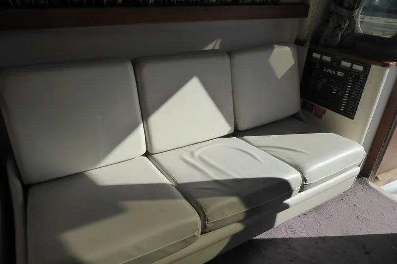 Slide: The Image of 1996 Luhrs 320 Tournament boat interior with white cushioned seating. - 18