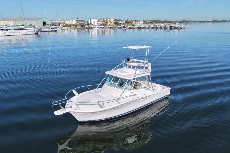 The Image of 2002 Luhrs 32 Open boat on calm water near marina. - 1