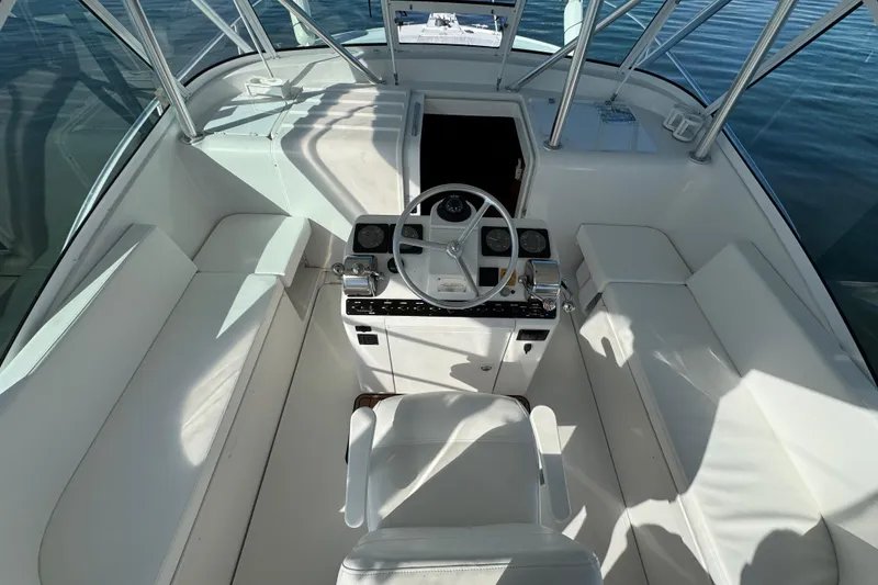 Slide: The Image of 2002 Luhrs 32 Open boat cockpit with steering wheel and seating, on calm water. - 13
