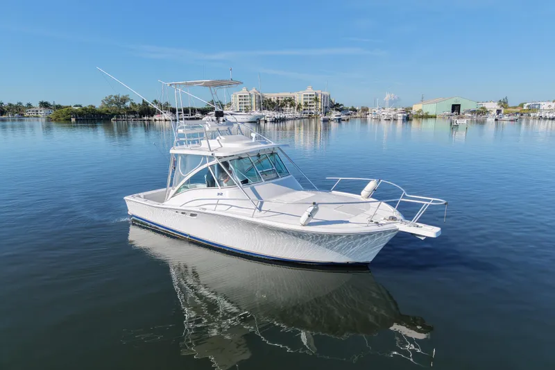 Slide: The Image of 2002 Luhrs 32 Open boat on calm water with marina background. - 3