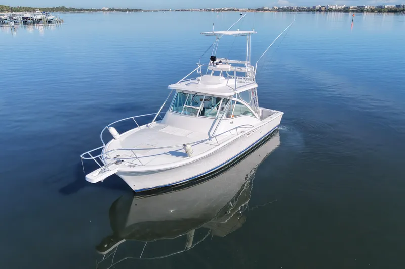 Slide: The Image of 2002 Luhrs 32 Open boat cruising on calm waters, showcasing sleek design and fishing capabilities. - 6