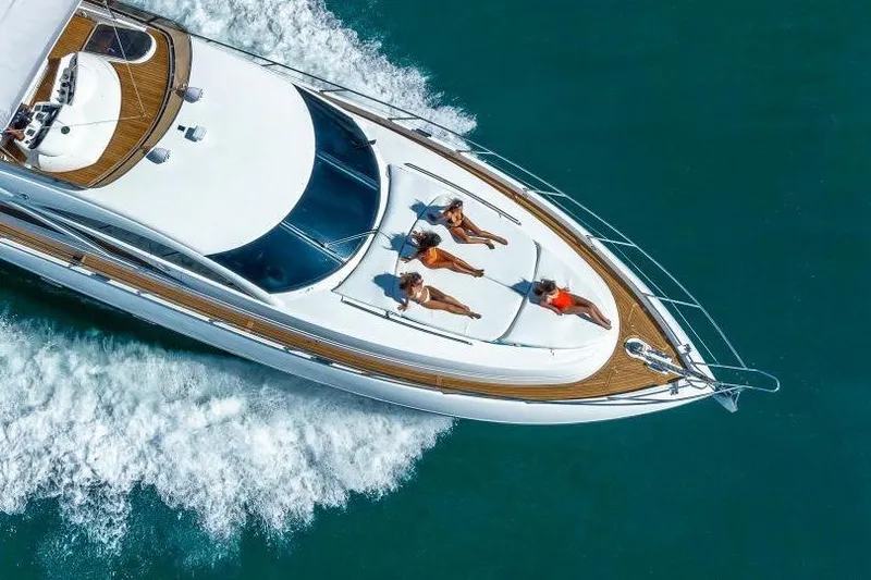Slide: The Image of Aerial view of Sunseeker Manhattan 74 yacht cruising with passengers sunbathing on deck. - 10