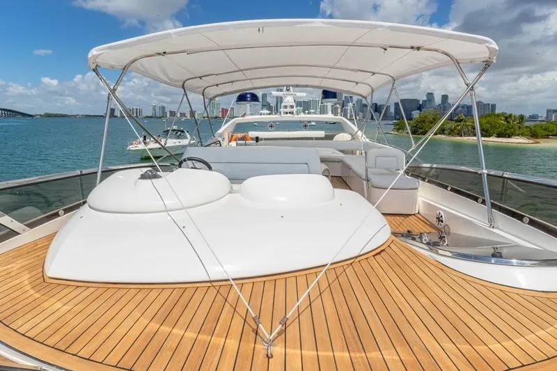 Slide: The Image of Sunseeker Manhattan 74 yacht, 2000 model, with spacious deck and canopy, cruising near city skyline. - 18