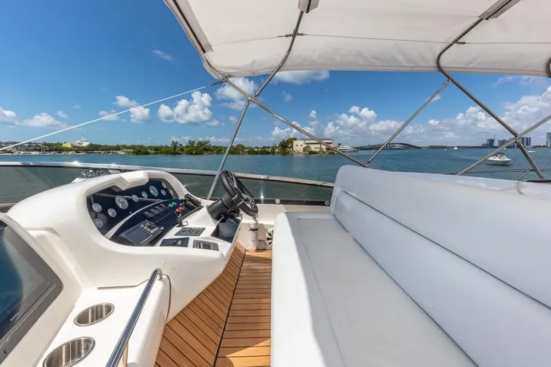 Slide: The Image of Sunseeker Manhattan 74 yacht helm with white seating, overlooking scenic water view. - 25