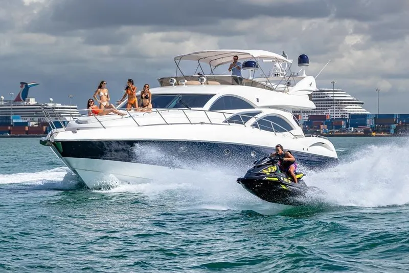 Slide: The Image of Luxurious Sunseeker Manhattan 74 yacht with people enjoying, accompanied by a speeding jet ski. - 4