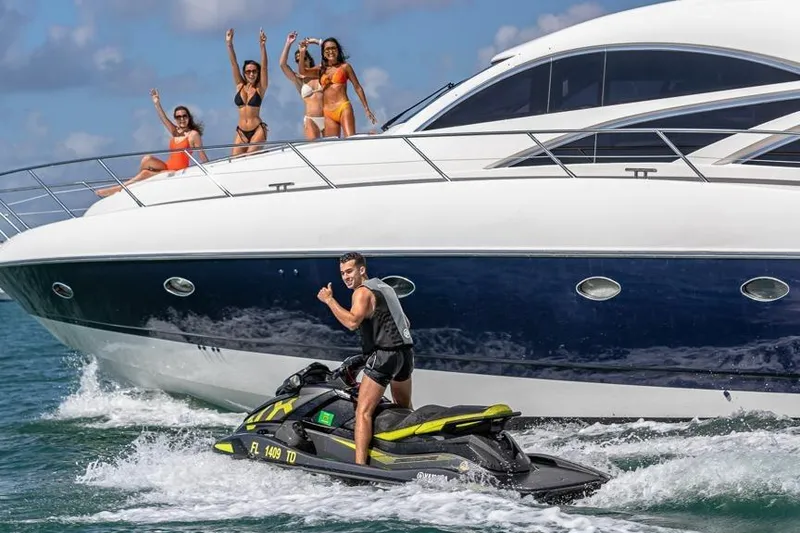 Slide: The Image of Man on jet ski near Sunseeker Manhattan 74 yacht, 2000 model, with people waving onboard. - 5