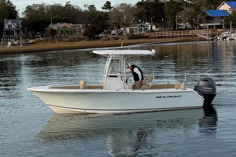 Slide: The Image of 2014 Sea Hunt Ultra 225 boat on calm water, with a person onboard. - 15