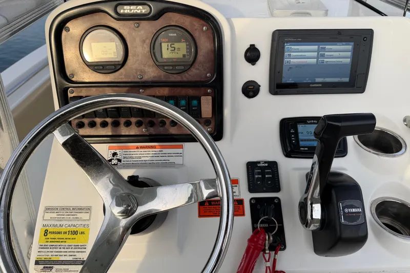 Slide: The Image of 2014 Sea Hunt Ultra 225 boat dashboard with steering wheel, gauges, and controls. - 16