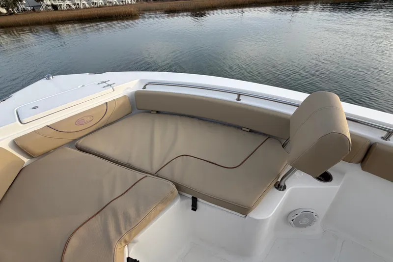 Slide: The Image of 2014 Sea Hunt Ultra 225 boat interior with beige seating, near calm water. - 21
