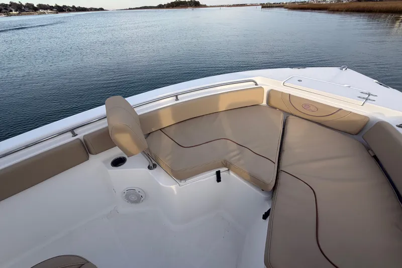 Slide: The Image of 2014 Sea Hunt Ultra 225 boat with beige seating, on calm water. - 23