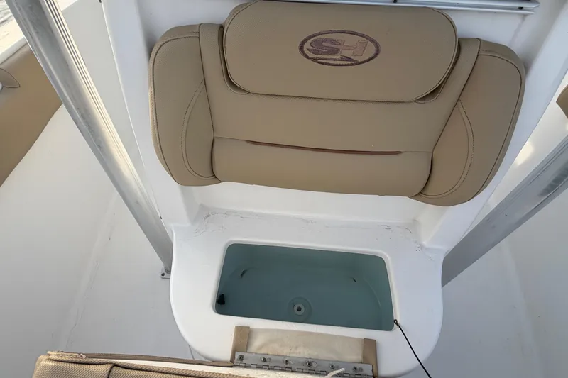 Slide: The Image of 2014 Sea Hunt Ultra 225 boat seat and livewell, featuring beige upholstery. - 33