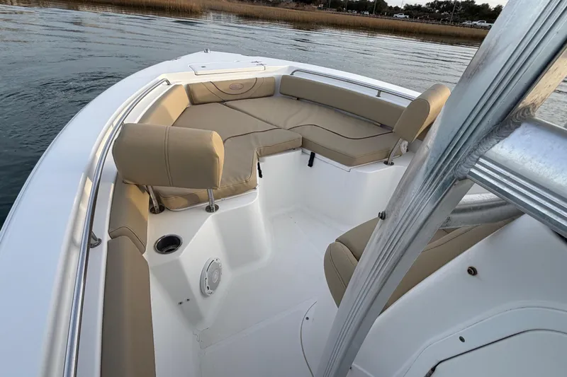 Slide: The Image of 2014 Sea Hunt Ultra 225 boat interior with cushioned seating on calm water. - 34