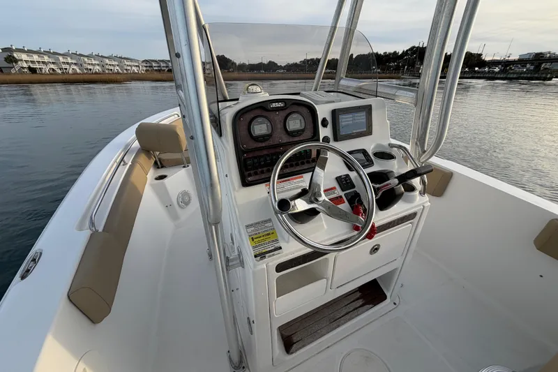 Slide: The Image of 2014 Sea Hunt Ultra 225 boat console with steering wheel and navigation equipment. - 36
