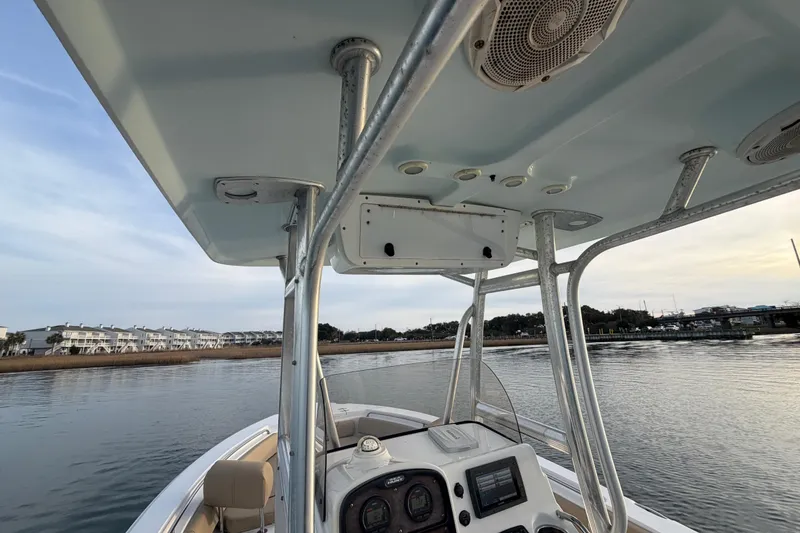 Slide: The Image of 2014 Sea Hunt Ultra 225 boat interior with console and T-top on calm water. - 37