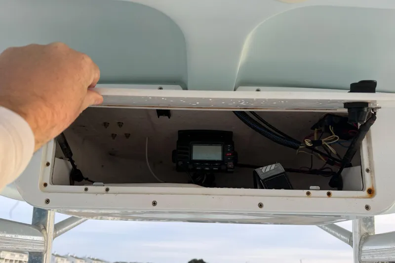 Slide: The Image of Open electronics compartment on 2014 Sea Hunt Ultra 225 boat, showing wiring and equipment. - 38