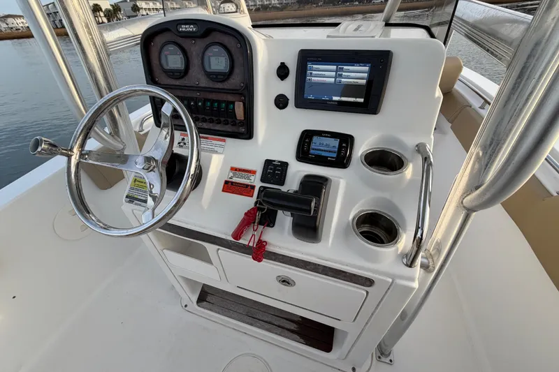 Slide: The Image of 2014 Sea Hunt Ultra 225 boat console with steering wheel and navigation controls. - 39