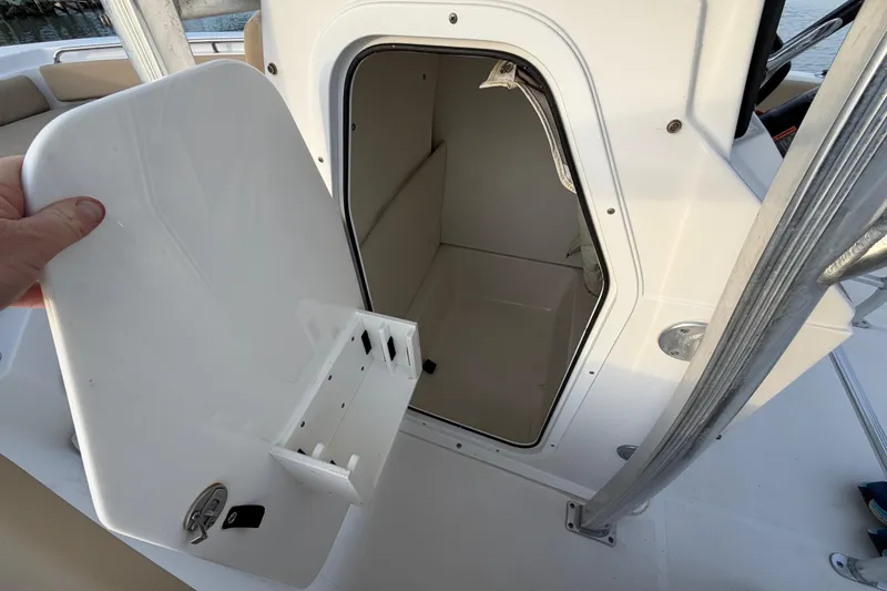 Slide: The Image of 2014 Sea Hunt Ultra 225 boat storage compartment with open door. - 50