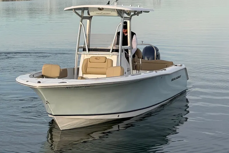 Slide: The Image of 2014 Sea Hunt Ultra 225 boat on calm water, featuring sleek design and comfortable seating. - 6