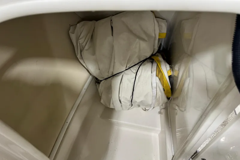 Slide: The Image of Storage compartment in a 2006 Monterey 234FS boat with folded white and yellow fabric. - 10