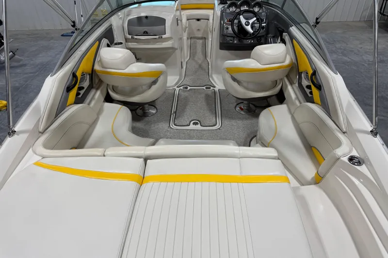 Slide: The Image of 2006 Monterey 234FS boat interior with white and yellow seating, steering wheel, and dashboard. - 18