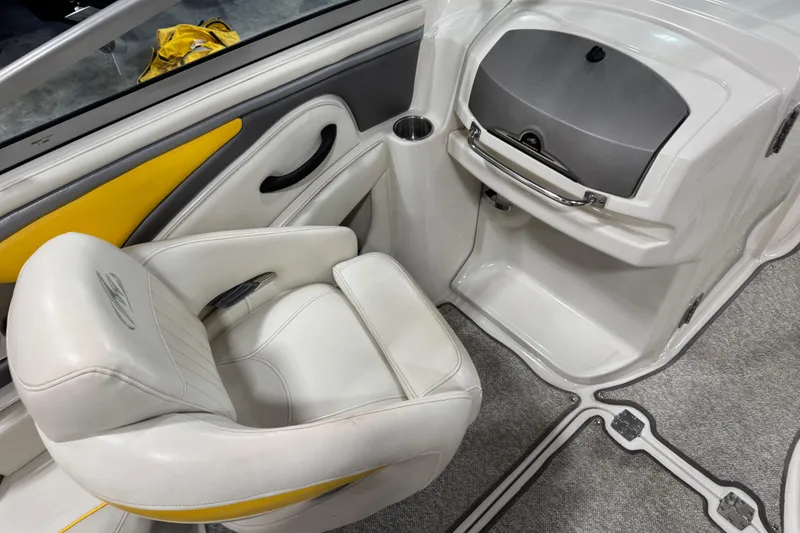 Slide: The Image of 2006 Monterey 234FS boat interior with white and yellow seating, gray dashboard, and carpeted floor. - 19