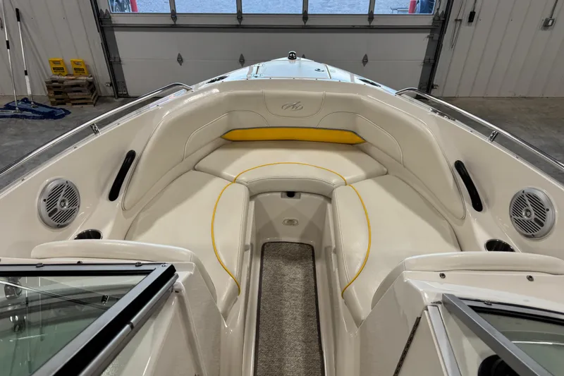 Slide: The Image of Interior of a 2006 Monterey 234FS boat with white seating and yellow accents. - 7