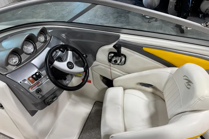 Slide: The Image of Interior of a 2006 Monterey 234FS boat, featuring steering wheel and gauges. - 8