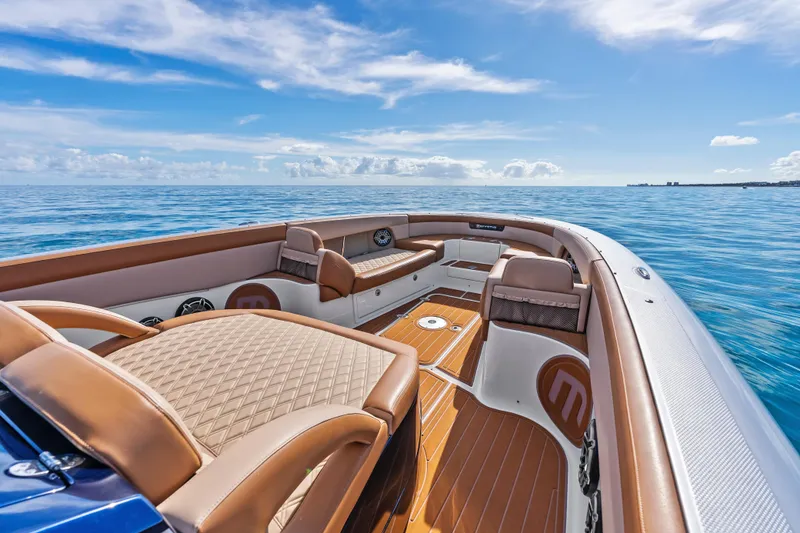 Slide: The Image of 2021 Mystic Powerboats M4200 interior with luxurious seating on open water. - 13