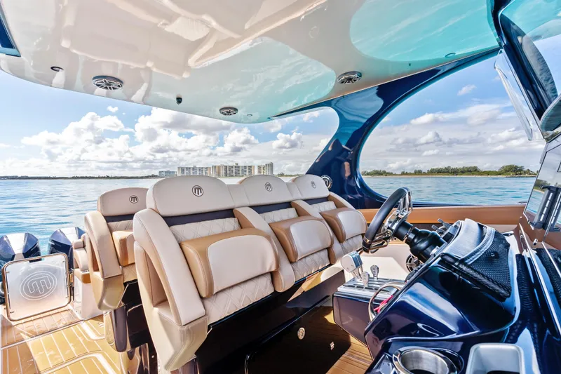 Slide: The Image of Luxurious 2021 Mystic Powerboats M4200 interior with plush seating and scenic ocean view. - 15